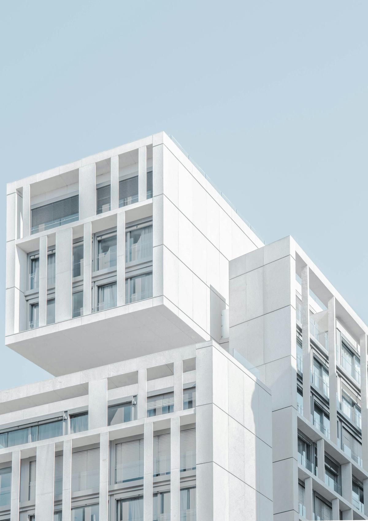 Building elevation design with stacked white modules and recessed glazing