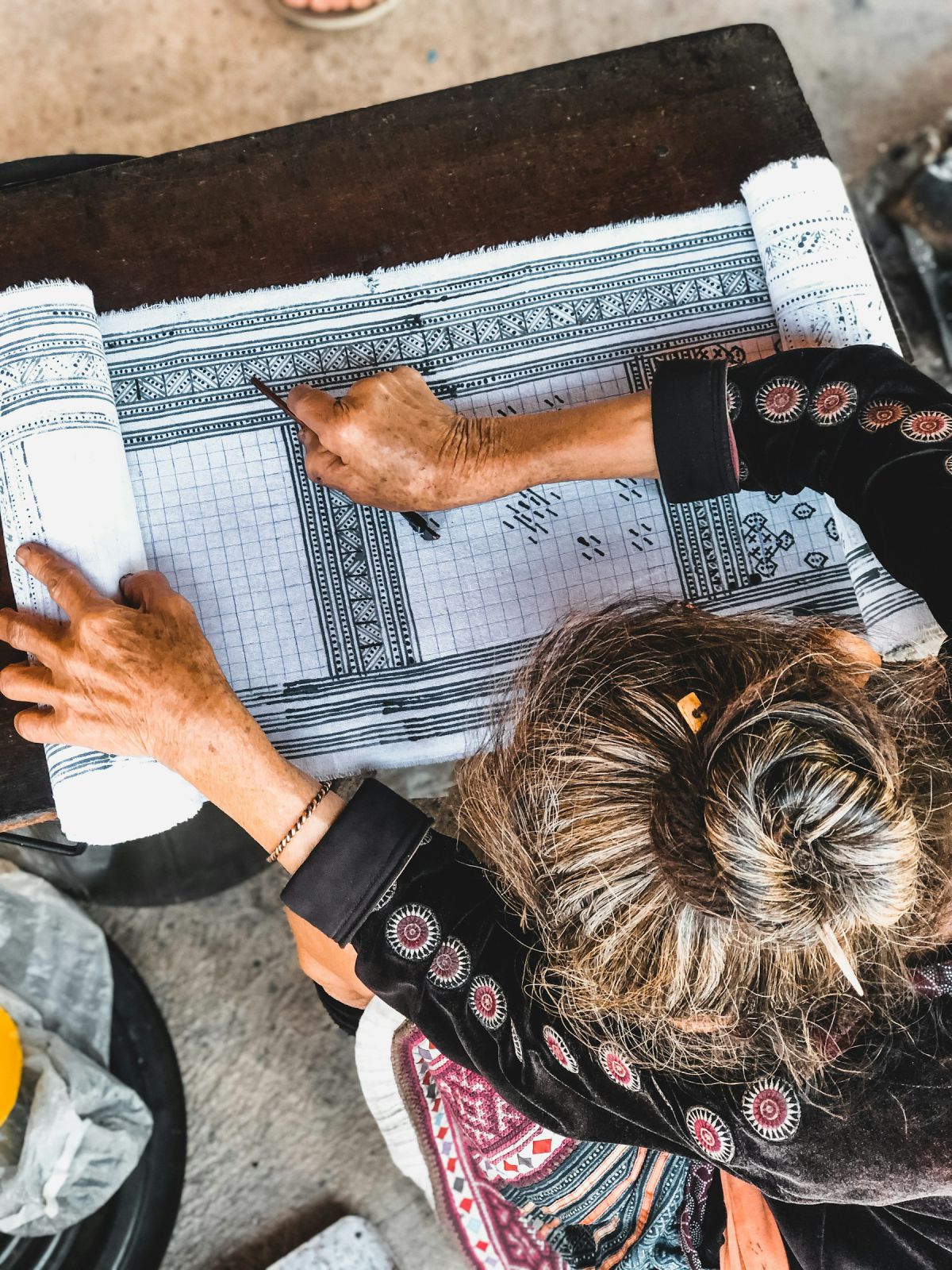 Indian architect with mehendi-adorned hands drafting plans on a drawing board Indian architect with mehendi-adorned hands drafting plans on a drawing board