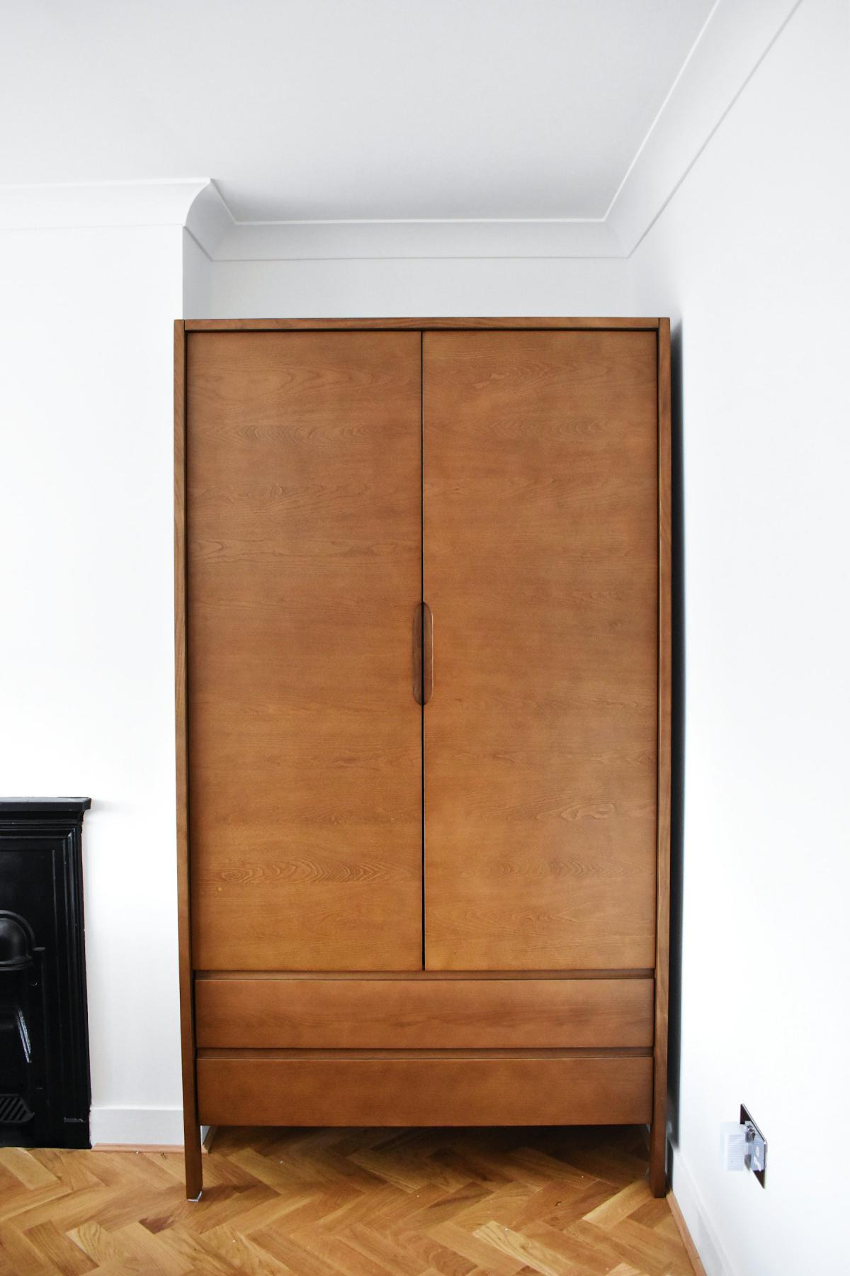 Wardrobe design in rich walnut wood veneer with full-height doors Wardrobe design in rich walnut wood veneer with full-height doors
