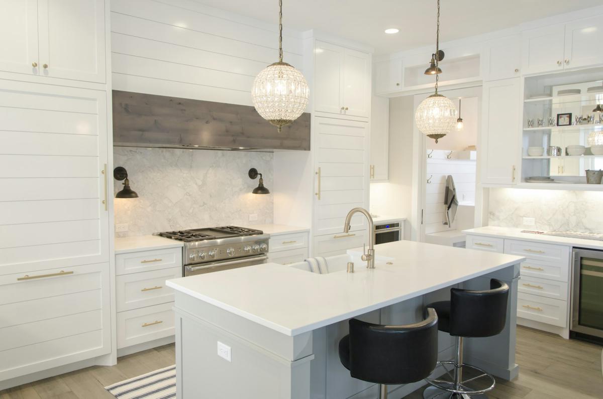 Luxury kitchen with large island, pendant lights and white cabinetry