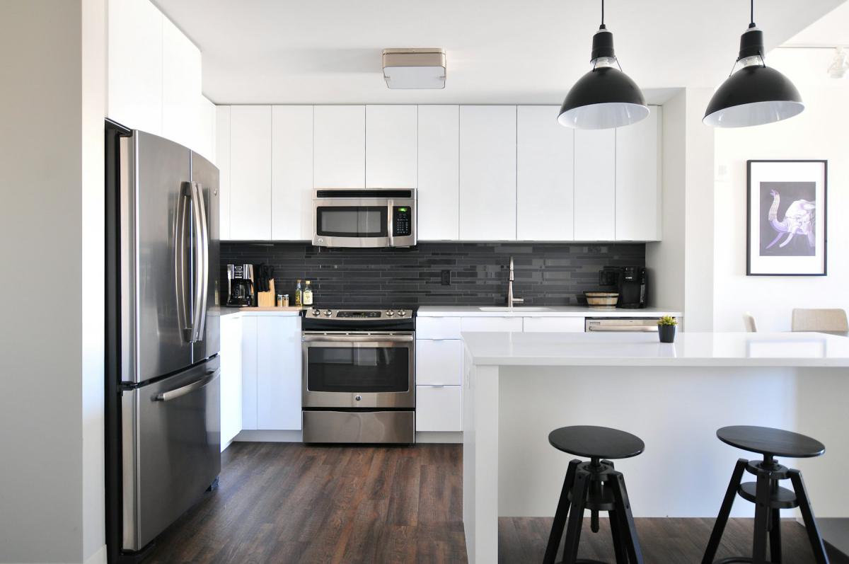 Modular Kitchen — Minimal white kitchen with island seating and black pendant lights
