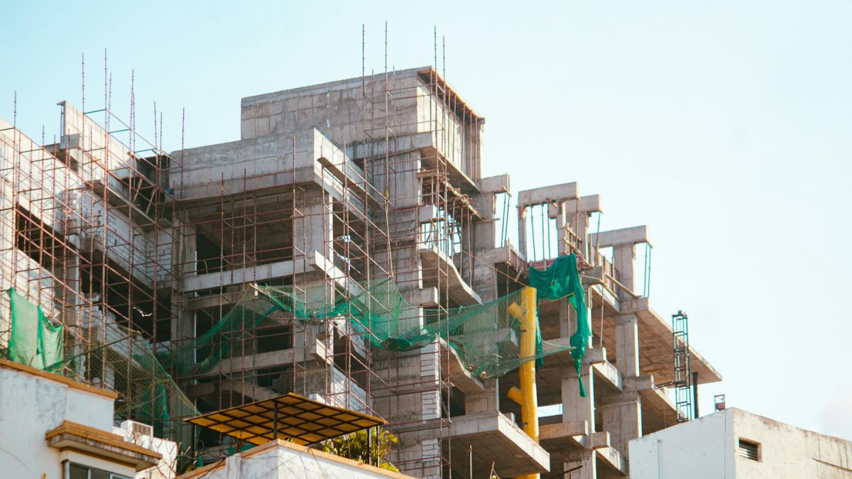 Reinforced concrete villa structure under construction with safety netting