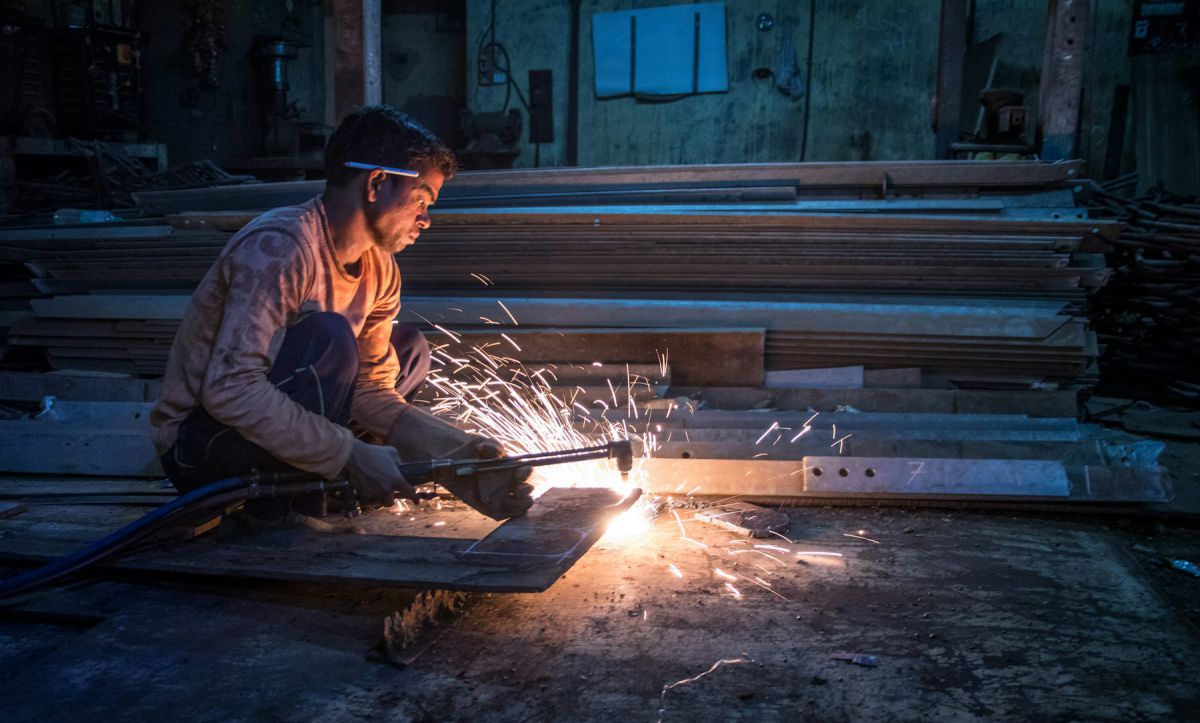Fabricator welding steel with sparks during on-site fit-out work